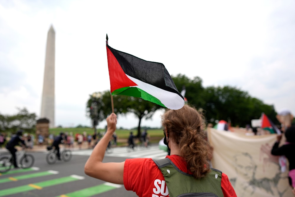 A demonstrator waves a Palestinian flag near the Washington Monument during a rally, Thursday, July 25, 2024, in Washington. (AP)