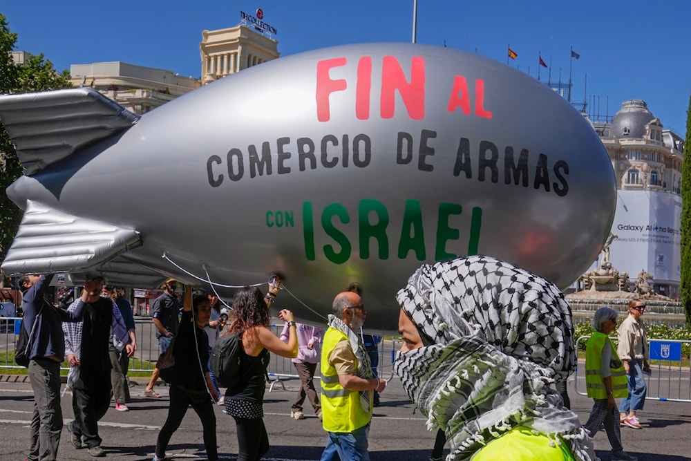 A blimp with the massage ' Stop the arms sales to Israel' is carried during a demonstration to show solidarity with Palestinians during a protest march in Madrid, Spain, Sunday, April 21, 2024. (AP)