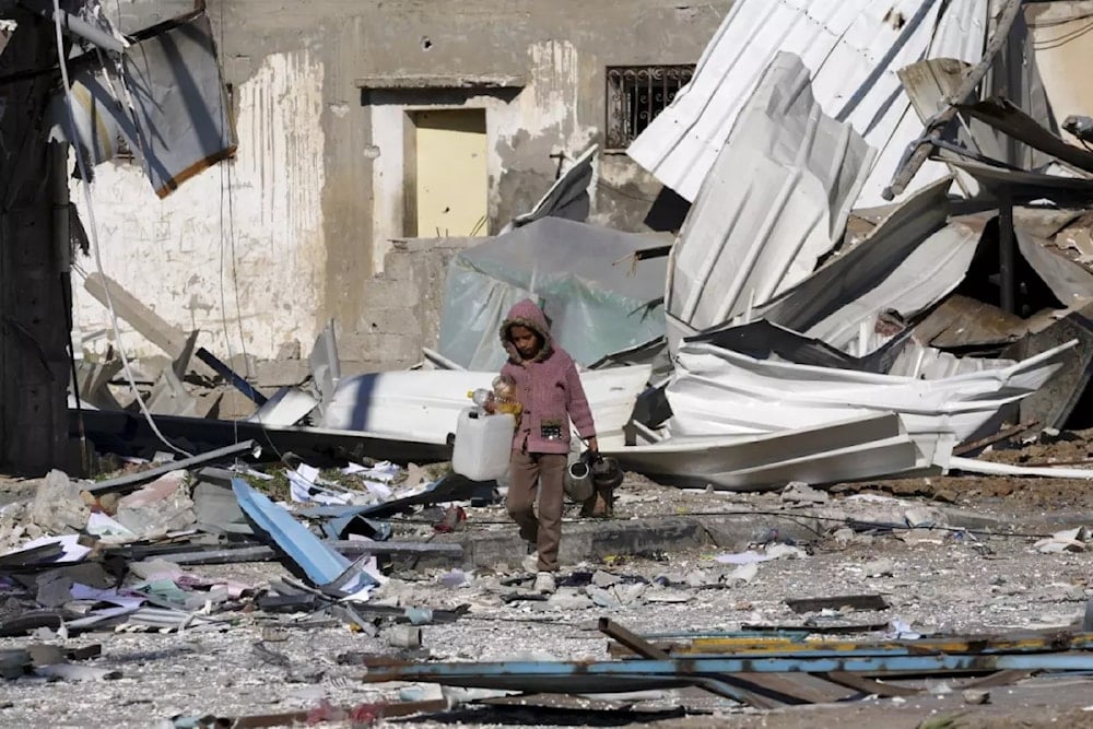 A Palestinian student walks past factories destroyed in the Israeli bombardment of the Gaza Strip in Deir al Balah on Jan. 13, 2024. (AP)