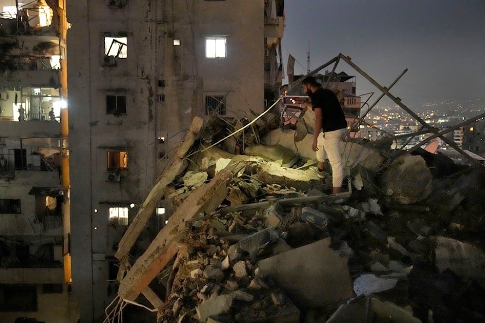 A man inspects a destroyed building that was hit by an Israeli airstrike in the southern suburbs of Beirut, Lebanon, Tuesday, July 30, 2024. (A)