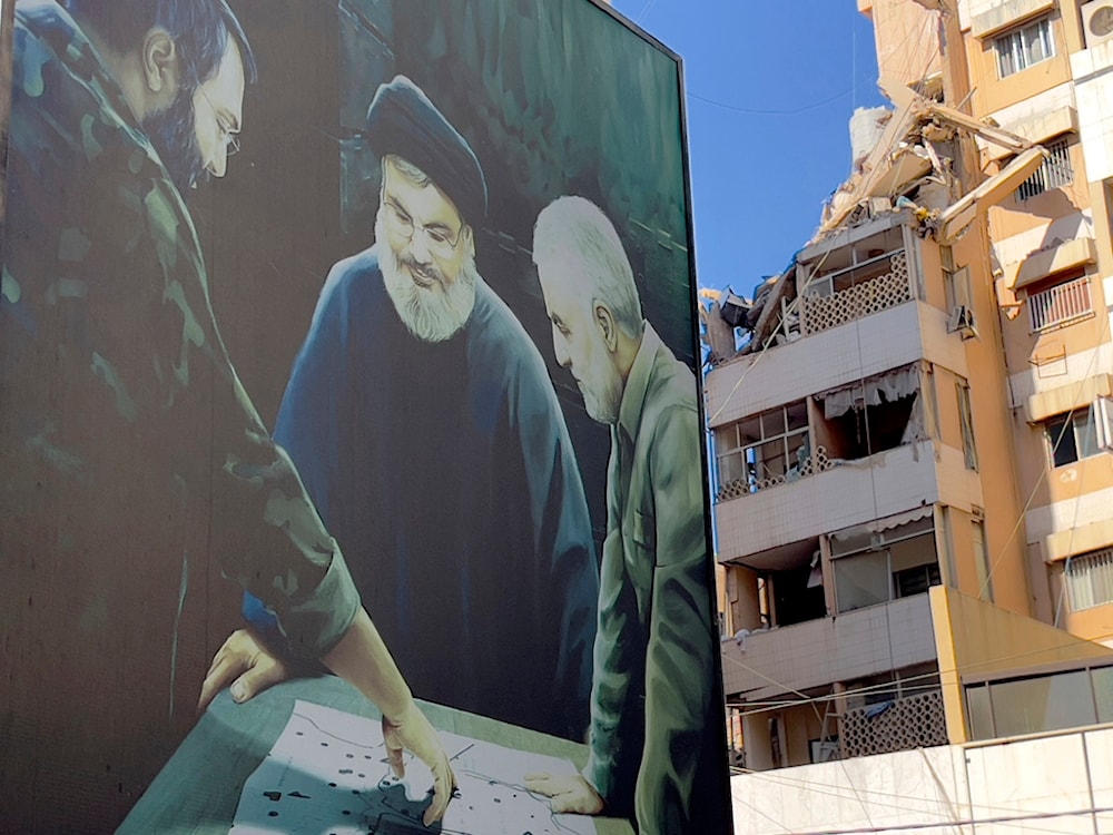 A poster showing Martyr Imad Mughniyeh, left, Hezbollah leader Sayyed Hassan Nasrallah, center, and Martyr Qassem Soleimani is set near the building hit by an Israeli airstrike in the southern suburbs of Beirut, Lebanon, July 31, 2024. (AP)