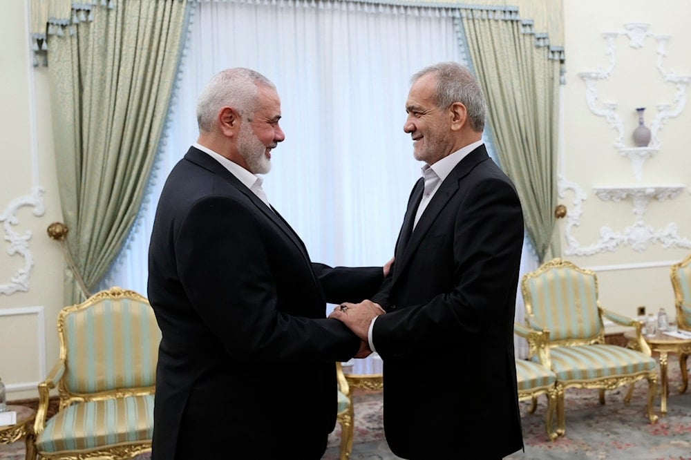 In this photo released by the Iranian Presidency Office, President Masoud Pezeshkian, right, shakes hands with Hamas chief Ismail Haniyeh at the start of their meeting at the President's office in Tehran, Iran, on July 30, 2024. (AP)