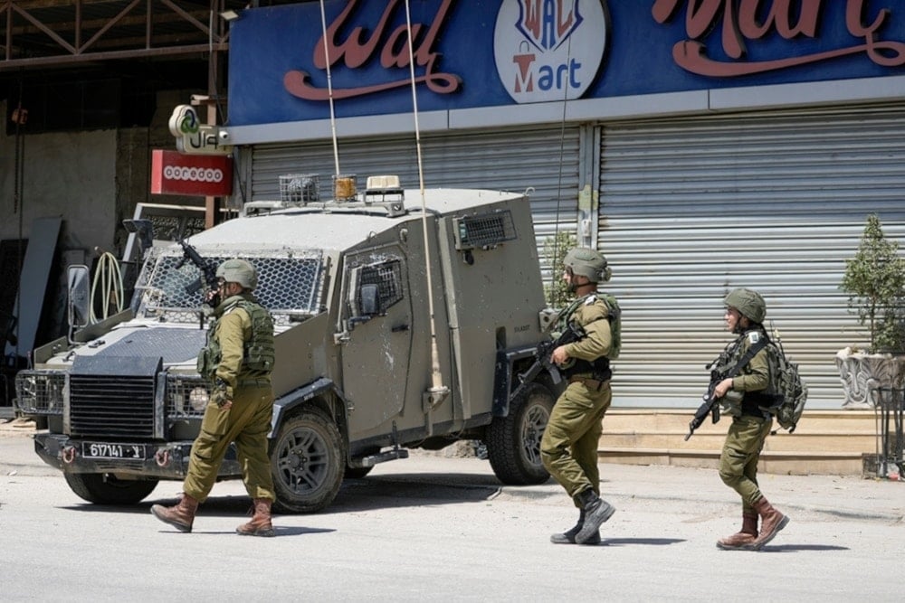 Israeli occupation officers walk back to their vehicles in the Palestinians al-Fara’a refugee camp in the occupied West Bank following the IOF military raid on Monday June 10,2024. (AP)