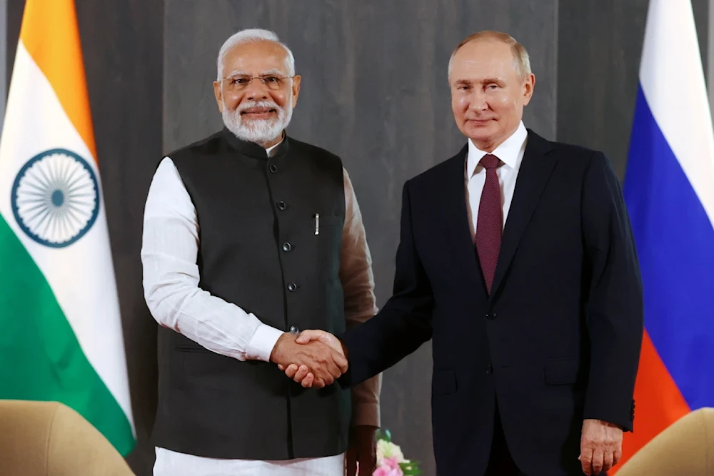 Russian President Vladimir Putin and Indian Prime Minister Narendra Modi pose for a photo shaking hands before their talks on the sidelines of the Shanghai Cooperation Organisation (SCO) summit in Samarkand, Uzbekistan, on September 16, 2022. (AP)