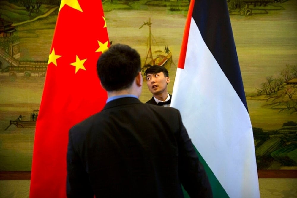 Staff members check the alignment of Chinese, left, and Palestinian flags before the start of a joint press conference at the Ministry of foreign affairs in Beijing, Thursday April 13, 2017. (AP) 