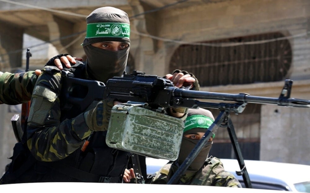 An al-Qassam Brigades Resistance fighter means a machine gun in the Jabalia refugee camp in the northern Gaza Strip, Palestine, on August 25,2021. (AP)