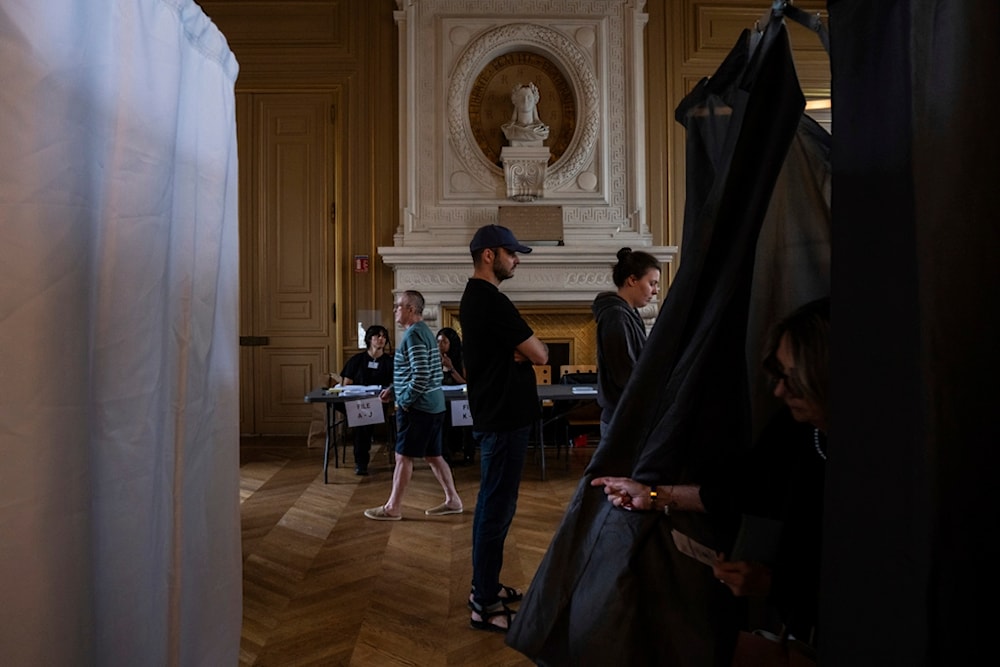 Voters line up to cast their vote during the second round of the legislative elections, Sunday, July 7, 2024 in Paris. (AP)
