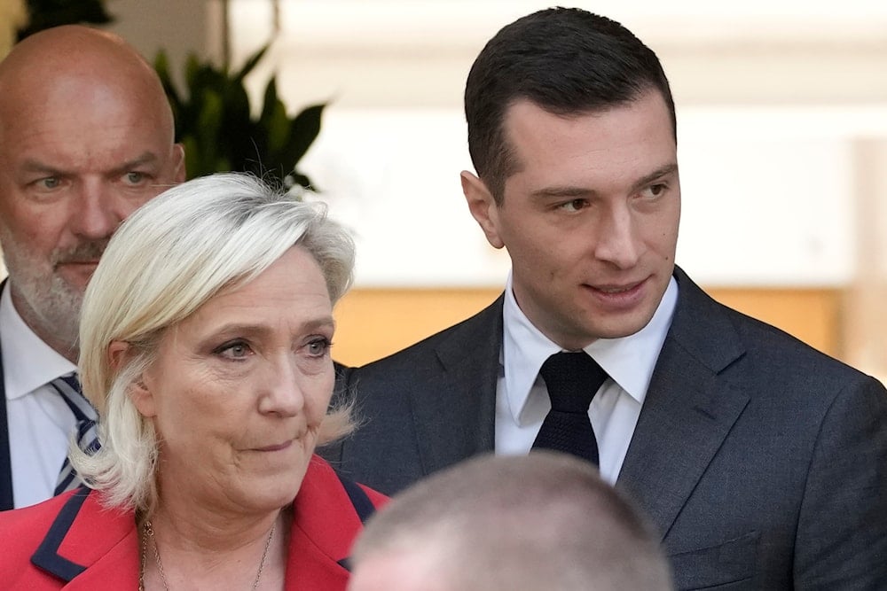 Far-right National Rally party president Jordan Bardella, right, leaves with far-right leader Marine Le Pen after a press conference, June 24, 2024, in Paris, France (AP)