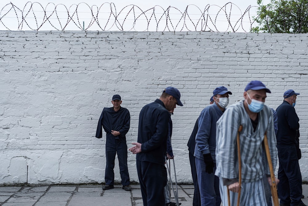 Russian prisoners of war stand in front of a wall at a detention center in the Lviv region, April 25, 2024 (AP)