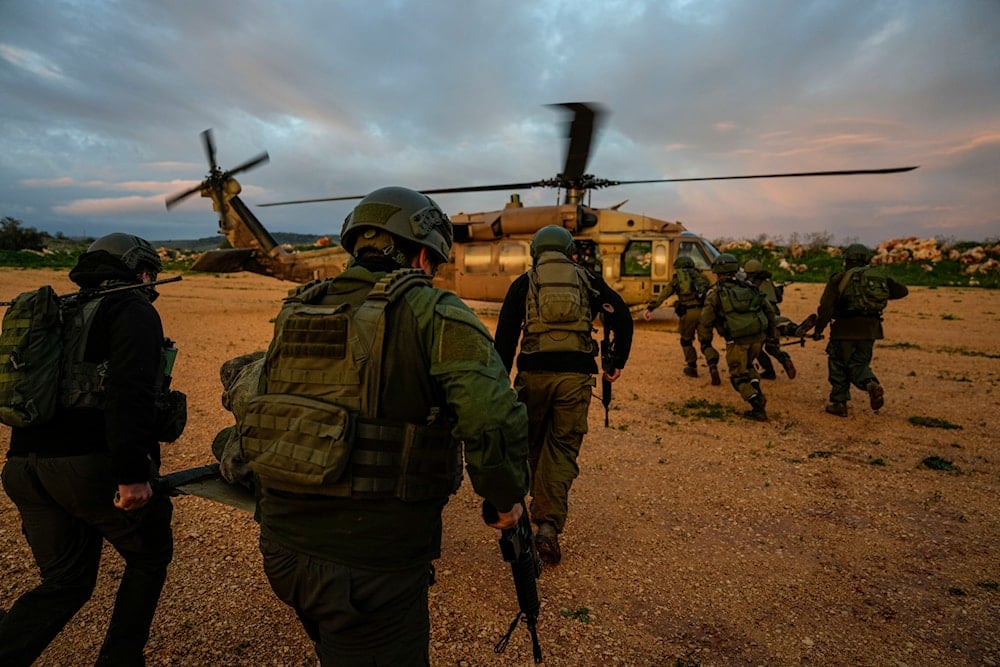 Israeli occupation forces carry stretchers towards a helicopter during an exercise simulating evacuation of wounded people in northern occupied Palestine, February 20, 2024 (AP)