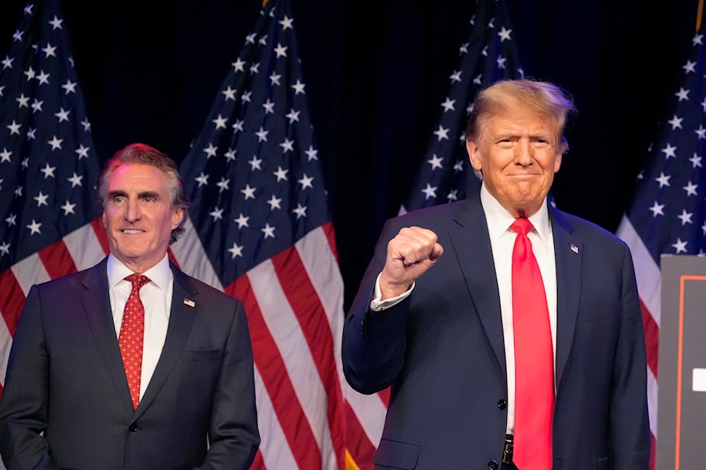 Republican presidential candidate former President Donald Trump, right, and North Dakota Governor Doug Burgum attend a caucus night rally, February 8, 2024, in Las Vegas (AP)