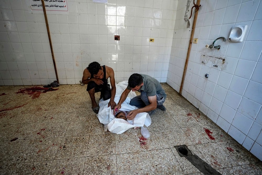 Palestinians mourn a relative killed in the Israeli bombardment of the Gaza Strip, at a hospital morgue in Deir al-Balah, Tuesday, July 9, 2024 (AP Photo/Abdel Kareem Hana)