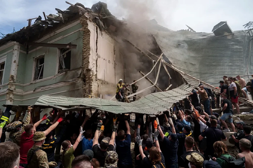 Hundreds of people rush to clear debris at the hospital, where windows are smashed and panels ripped off. July 8, 2024. (AP)