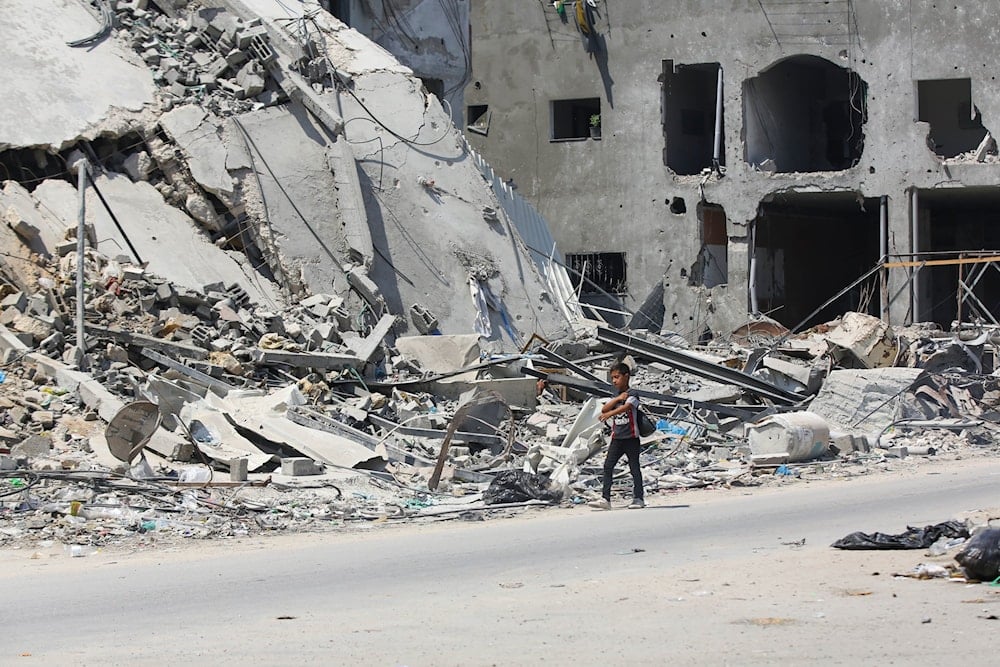 A Palestinian child walking alongside a residential building reduced to rubble by Israeli relentless bombing June 24,2024. (UNRWA)