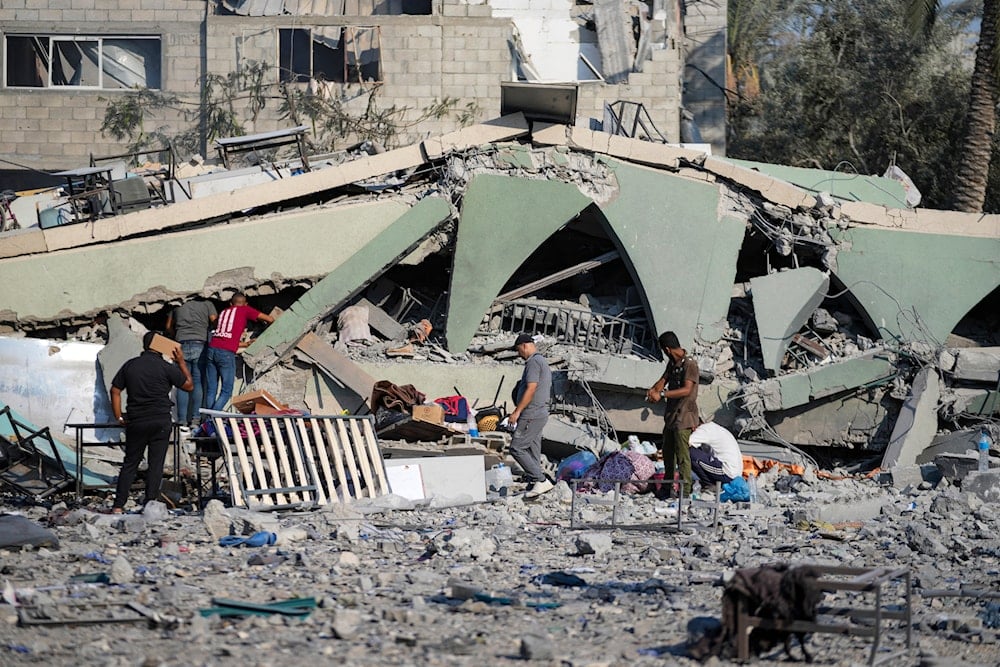 Palestinians inspect the rubble of a school destroyed in an Israeli airstrike on Deir al-Balah, central Gaza Strip, Saturday, July 27, 2024 (AP)