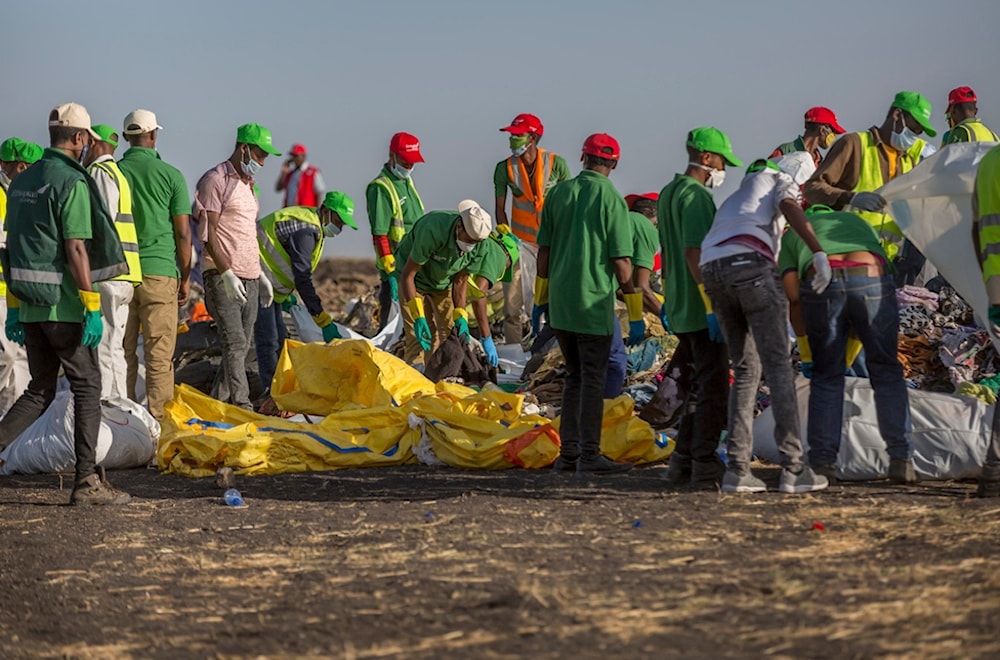 Workers collect debris on March 12, 2019, at the scene where an Ethiopian Airlines Boeing 737 Max 8 crashed shortly after takeoff. (AP)