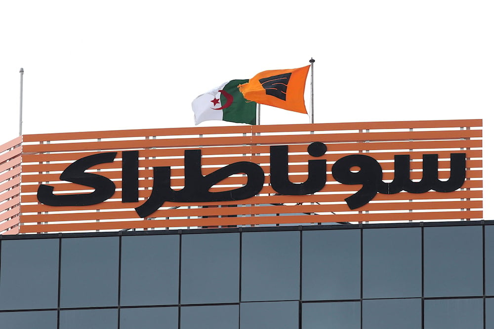 The flag of the Algerian Sonatrach group flies next to the Algerian flag on its headquarters in Algiers, Thursday, February 8, 2018 (AP)