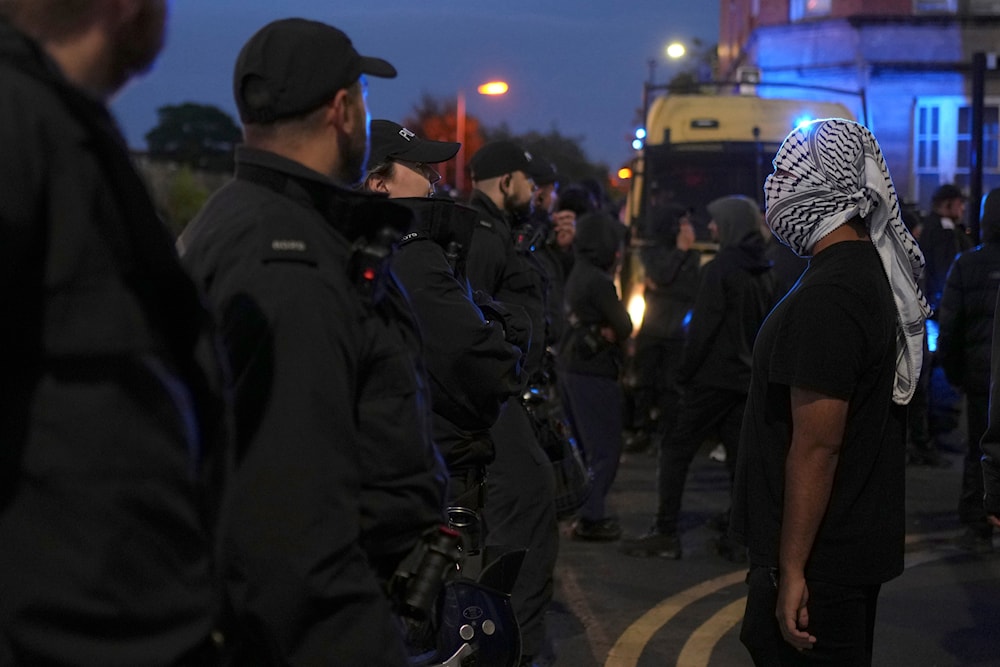 A counter protester stands in front of police in Liverpool, on August 7, 2024. (AP)