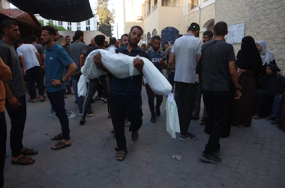 A man carries a relative killed during August 10 al-Tabieen school masssacre from the hospital for burial.(AFP)