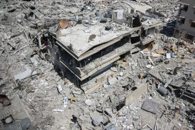 A Palestinian man walks on building rubble in a devastated area around Gaza's Shifa hospital on April 3, 2024 due to deliberate Israeli bombardments (AFP Via Getty Images)