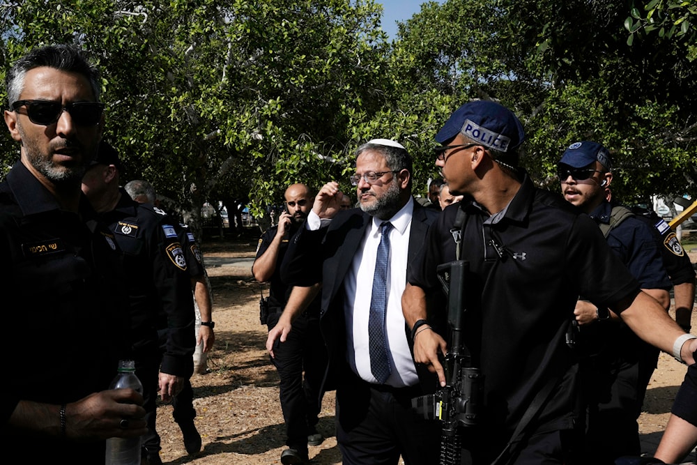 Israel's National Security Minister Itamar Ben-Gvir, center, visits the site of a stabbing attack that, Israeli police said, a Palestinian attacked killed a woman and wounded a few others in Holon, Israel Sunday, August 4, 2024. 