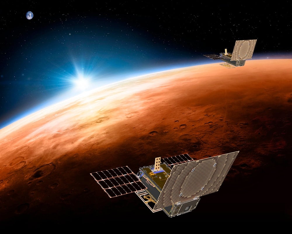  This illustration made available by NASA on March 29, 2018 shows the twin Mars Cube One (MarCO) spacecraft flying over Mars with Earth and the sun in the distance. (AP)