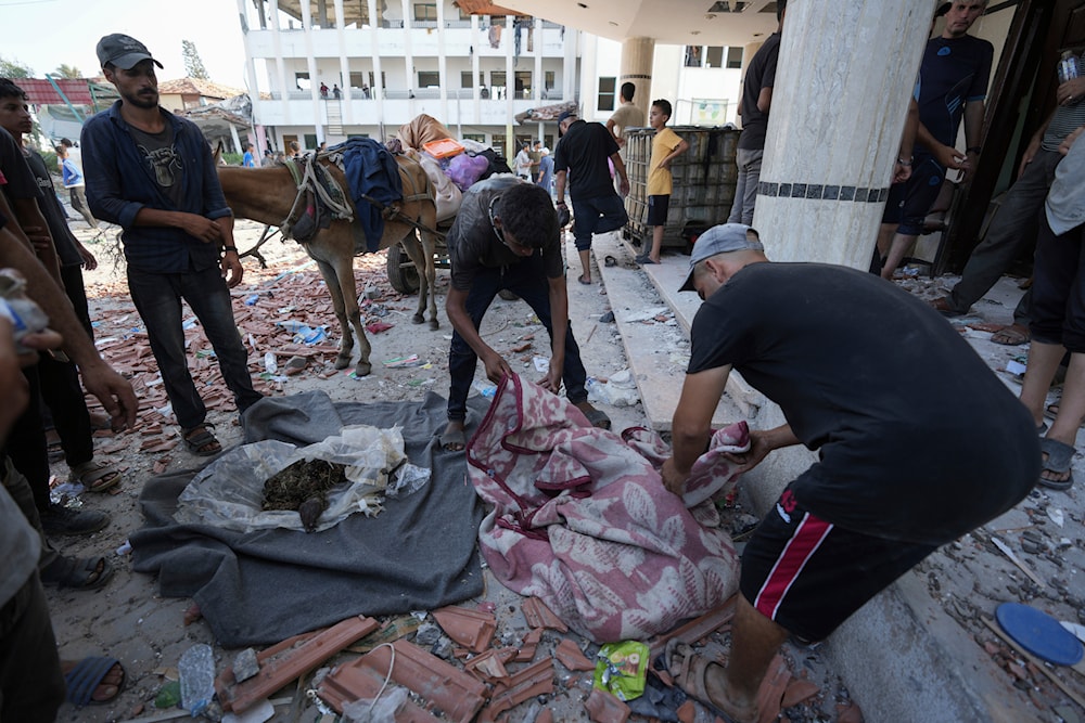 Palestinians search for bodies in the rubble of a school destroyed in an Israeli airstrike on Deir al-Balah, central Gaza Strip, on July 27, 2024. (AP)