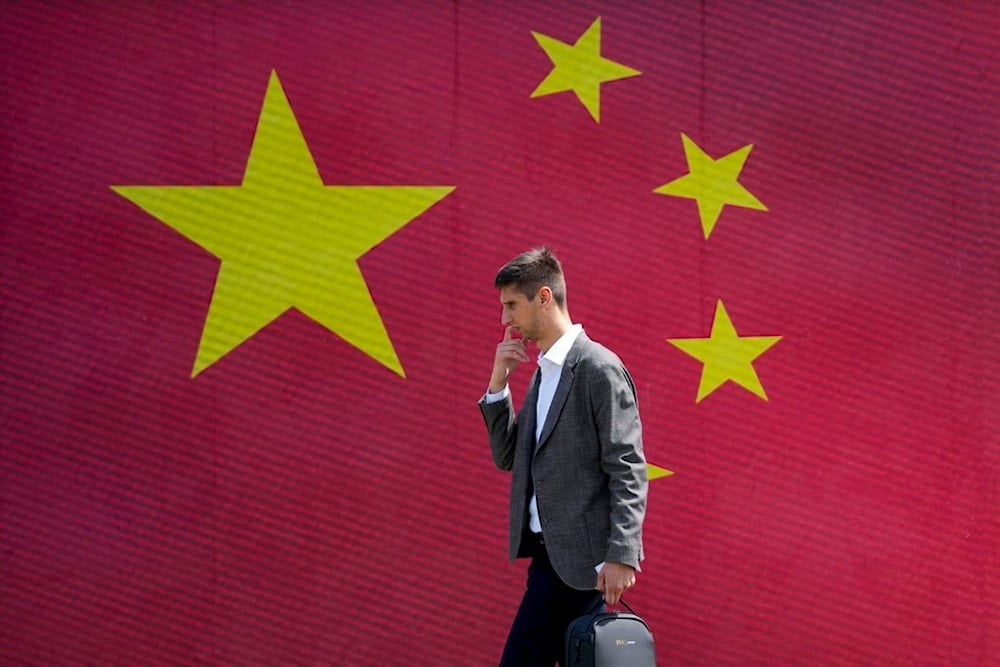 A man walks in front of a Chinese national flag in Belgrade, Serbia, Tuesday, May 7, 2024. (AP)