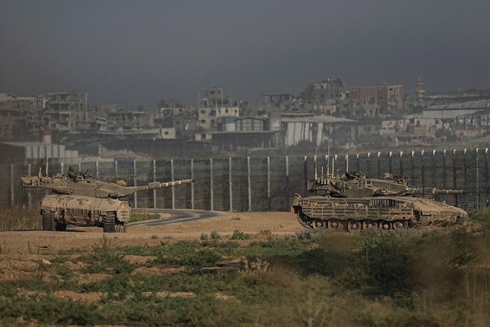 Israeli tanks stand near the separation line with Gaza as seen from southern occupied Palestine Sunday, July 14, 2024. (AP Photo/Tsafrir Abayov)