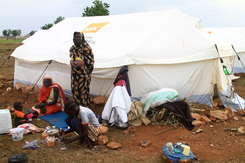 Women and children sit outside their tent, set up at a camp for internally displaced Sudanese from Sennar state, in the al-Huri district of Gedaref city east of war-torn Sudan on July 14,202. (AFP)