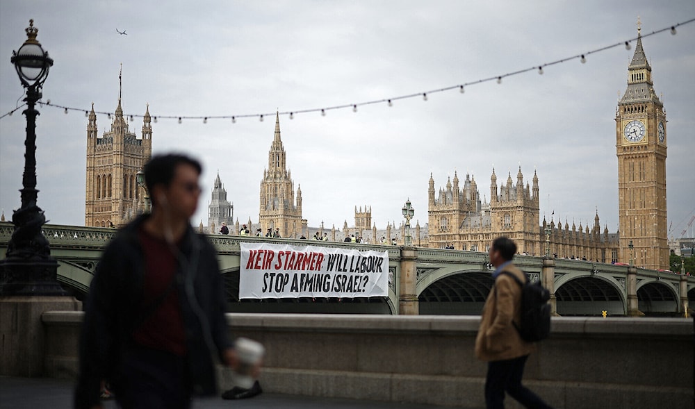 A banner reading 'Keir Starmer: Will Labour Stop Arming Israel?' is hung over the side of Westminster Bridge, in front of the Palace of Westminster, in London on June 3, 2024. (AFP)