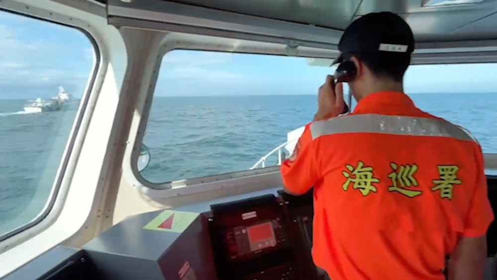 A Taiwanese Coast Guard Administration member calls out for a Chinese Coast Guard ship at left to leave from the area around Kinmen, July 11, 2024. (Taiwan Coast Guard Administration via AP)