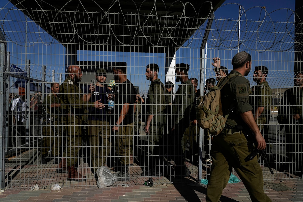 Israeli soldiers gather at the gate to the Sde Teiman detention camp and military base, Monday, occupied Palestine, July 29, 2024 (AP)