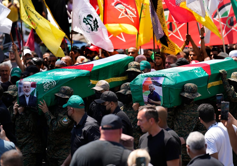 Hamas fighters carry mock coffins of Hamas political chief Ismail Haniyeh and his bodyguard who was killed in an assassination in Tehran, during a symbolic funeral in Beirut, Lebanon, Friday, August 2, 2024 (AP)