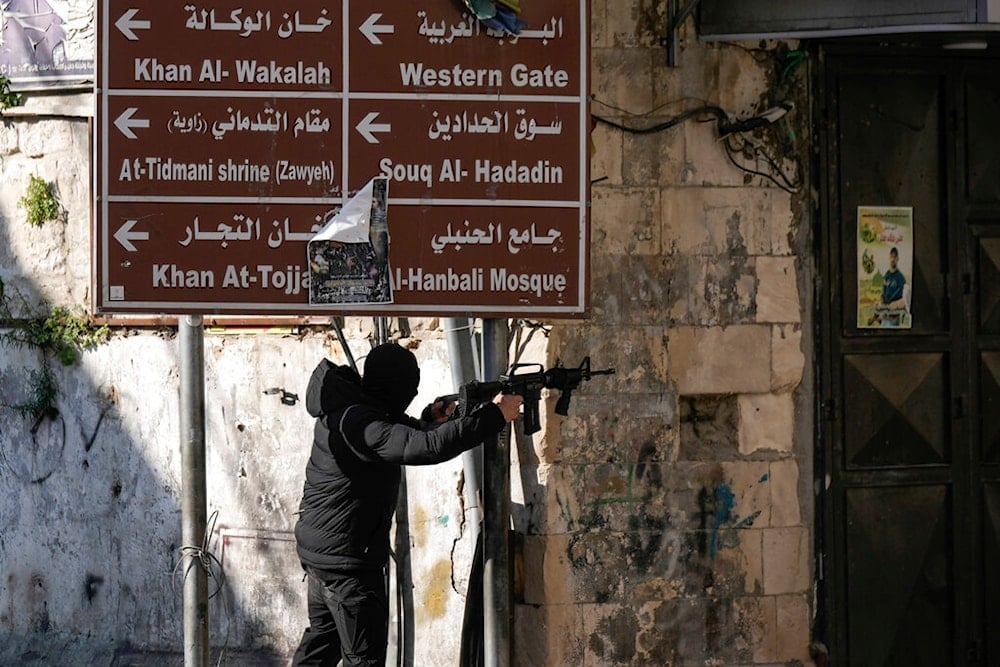 A masked Palestinian fighter fires confronts Israeli occupation forces in the West Bank city of Nablus. Friday, Dec. 30, 2022. (AP)