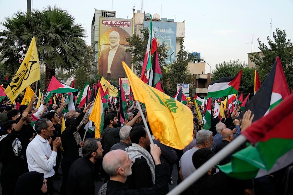 Iranian protesters wave Iranian, Palestinian, and Hezbollah group flags in a demonstration to condemn the killing of Hamas leader Ismail Haniyeh, at Felestin (Palestine) Sq. in Tehran, Iran, Wednesday, July 31, 2024 (AP)