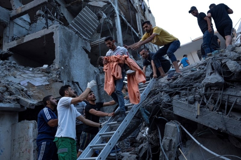  Palestinains rescue a young girl from the rubble of a destroyed residential building following an Israeli airstrike on Gaza, Ocyober 10,2023. (AP