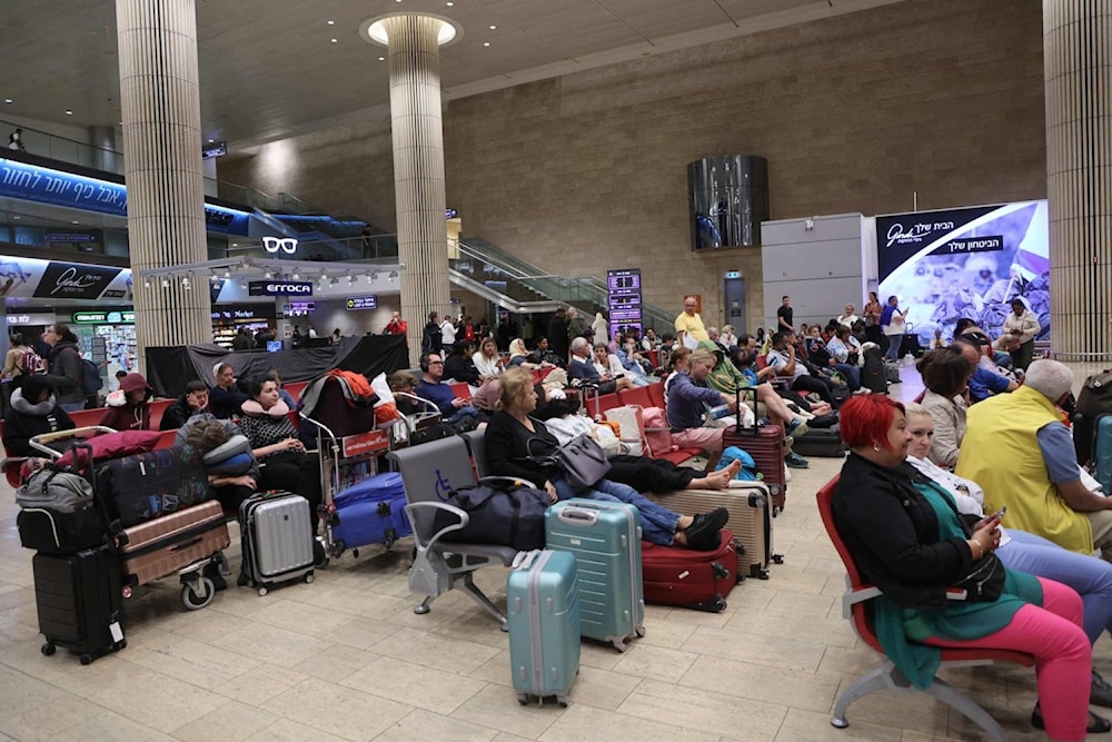 Passengers wait at Ben Gurion Airport near Tel Aviv on October 7, 2023 (AFP)