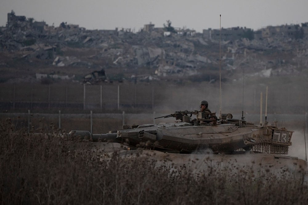 Israeli soldiers move on the top of a tank near the Gaza border, as seen from southern occupied Palestine, Wednesday, Aug. 21, 2024. (AP