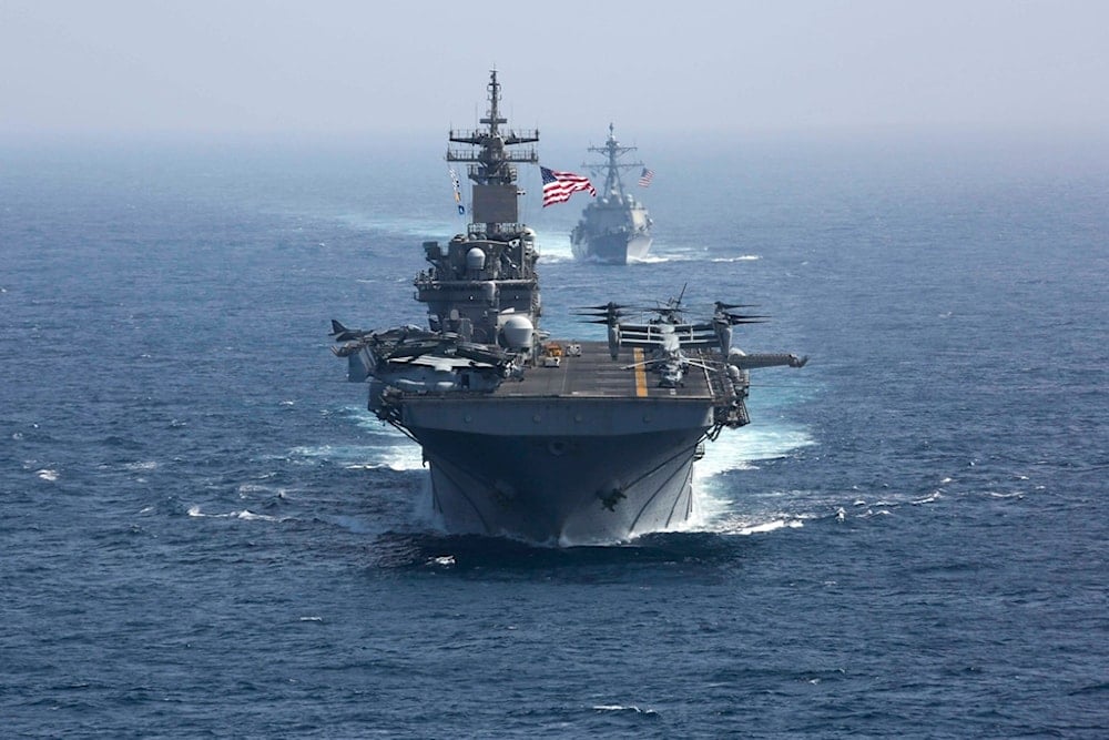 The amphibious assault ship USS Kearsarge and the Arleigh Burke-class guided-missile destroyer USS Bainbridge sail as part of the USS Abraham Lincoln aircraft carrier strike group in the Arabian Sea.