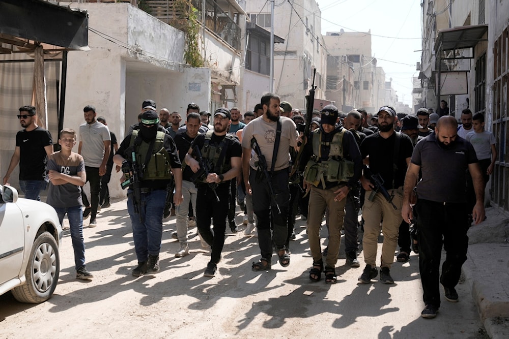 Freedom fighters march during a funeral for martyred Palestinians draped in the Hamas flag and killed in an Israeli airstrike in the Jenin refugee camp, in the West Bank city of Jenin, Aug. 18, 2024. (AP)