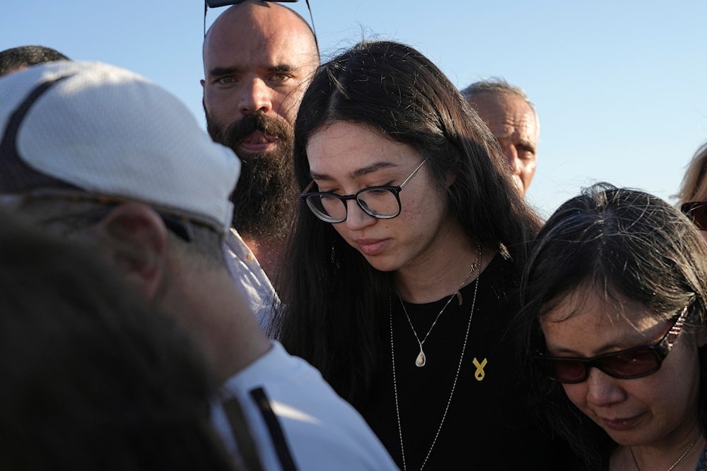 Freed Israeli hostage Noa Argamani, center, stands at the grave of her mother Liora Argamani, during her funeral in Beersheba, 