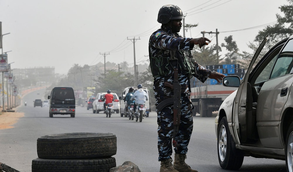 A police officer stops a car at a checkpoint to check the activities of criminals and unknown gunmen in Anambra State, southeast Nigeria, on February 16, 2023. (AFP)