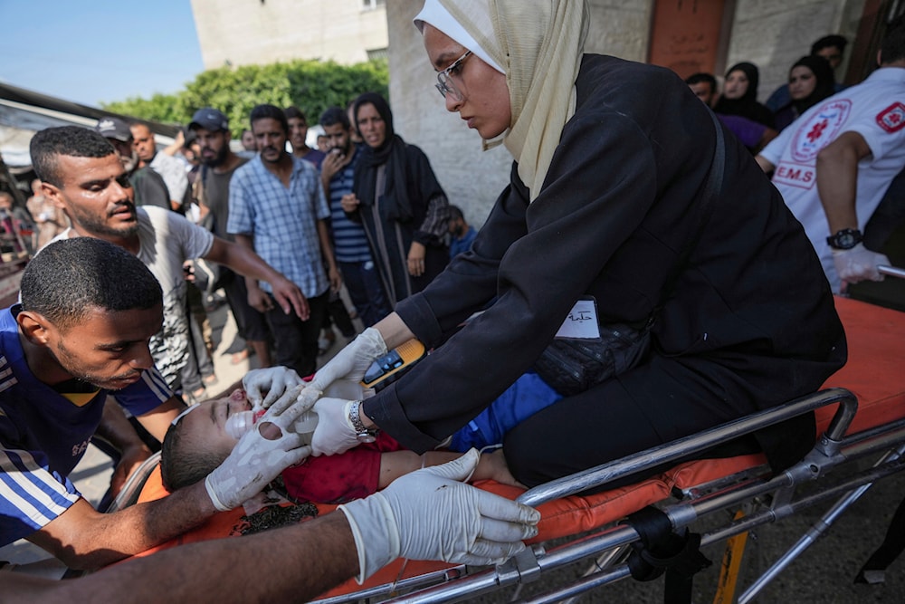 A Palestinian medic helps a child wounded in the Israeli bombardment of the Gaza Strip in a hospital in Deir Al-Balah, on July 27, 2024. (AP)