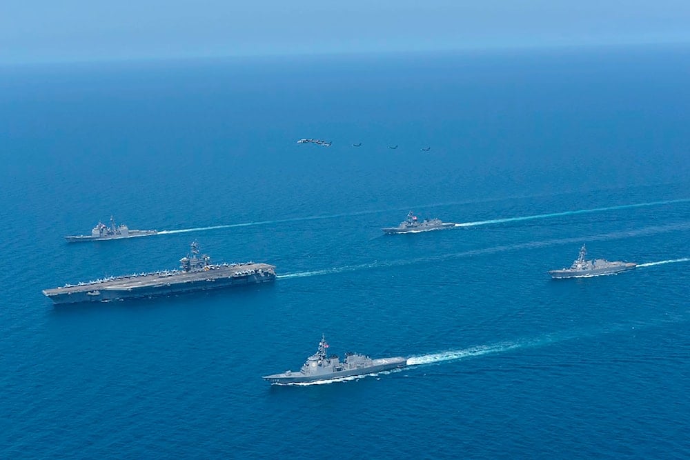 This photo shows USS Abraham Lincoln, left, and JS Kongo, front, sail in formation during a US-Japan bilateral exercise at the Sea of Japan on April 12, 2022.