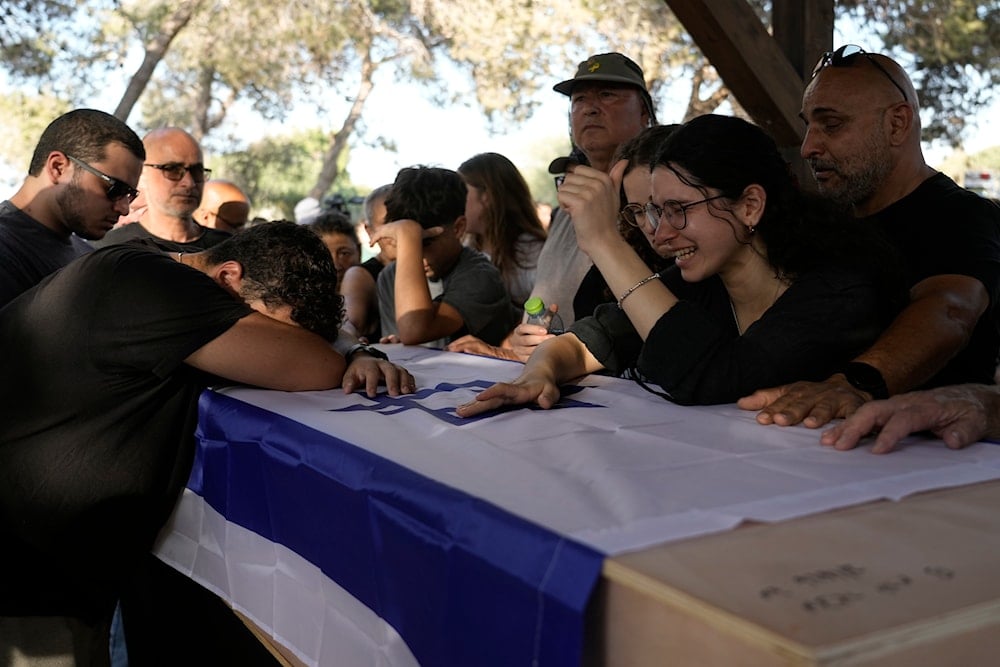 Family members mourn over the coffin of an Israeli soldier during his funeral at a cemetery of Nir Oz, southern occupied Palestine, Thursday, August 22, 2024 (AP)