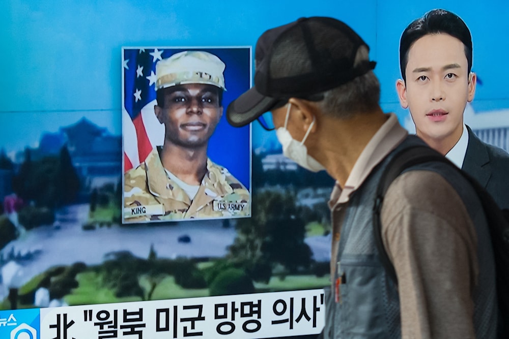 In this photo taken in Seoul on August 16,2023, a man walks past a television showing a news broadcast featuring a photo of US soldier Travis King . (AFP)