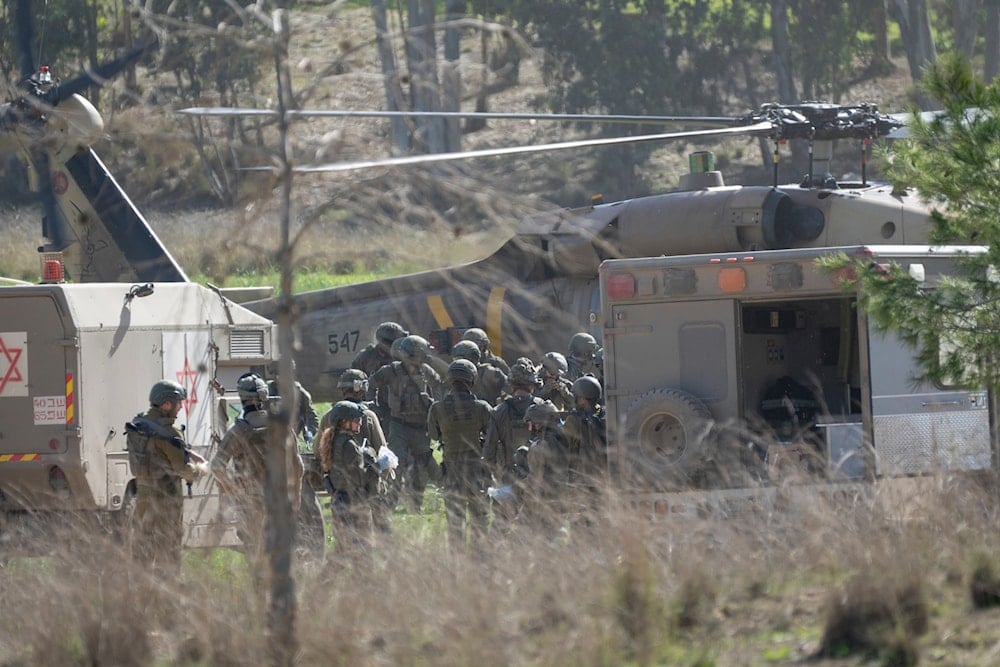 A military helicopter transfers a wounded soldier to a military ambulance near the Gaza Strip, in southern occupied Palestine, Thursday, January 18, 2024 (AP)