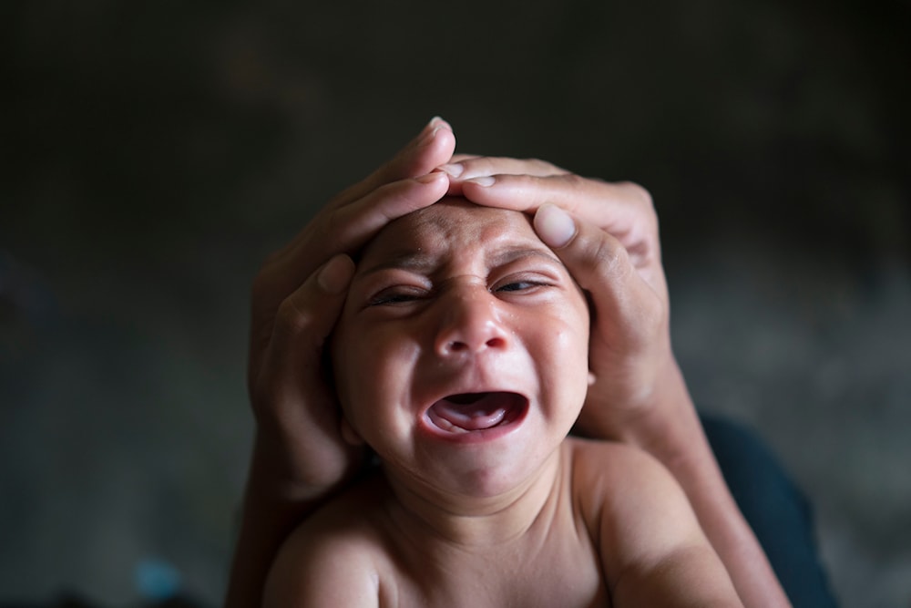 Elielson tries to calm down his baby brother Jose Wesley, in Bonito, Pernambuco state, Brazil on Jan. 30, 2016. (AP)