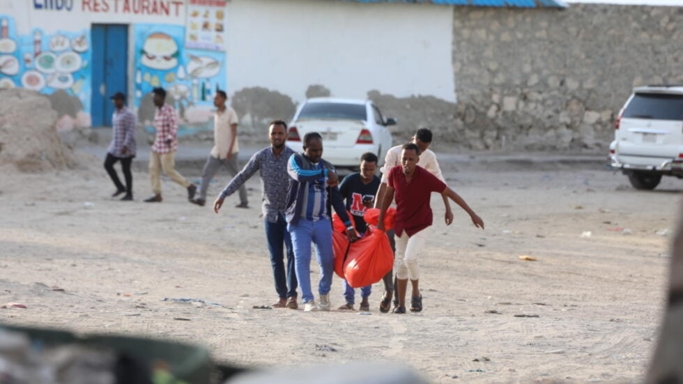 Somalians carrying a body after a terrorist attack on Lido Beach in Mogadishu, Somalia on August 3, 2024 (AFP)